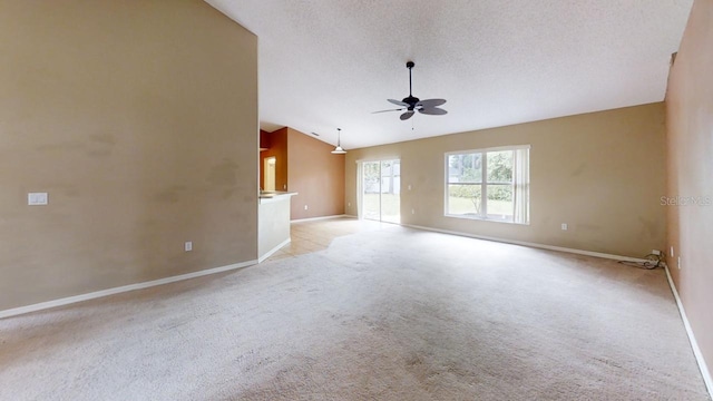 unfurnished living room with vaulted ceiling, light carpet, ceiling fan, and a textured ceiling