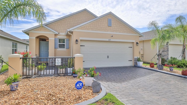 view of front of property with a garage, decorative driveway, and stucco siding