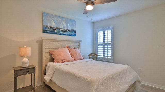 bedroom featuring a ceiling fan, baseboards, and wood finished floors