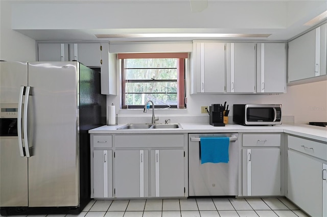 kitchen featuring light tile patterned flooring, stainless steel appliances, sink, and white cabinets