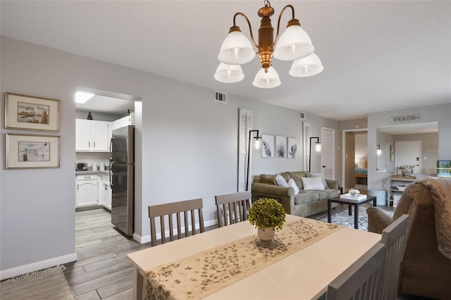 dining area with a chandelier and light hardwood / wood-style floors