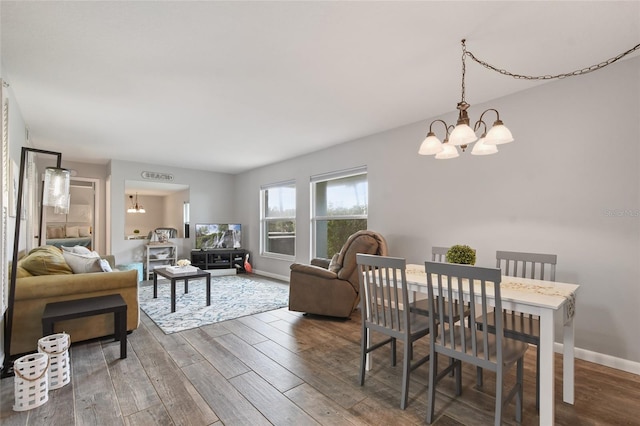 dining space with a notable chandelier and dark wood-type flooring