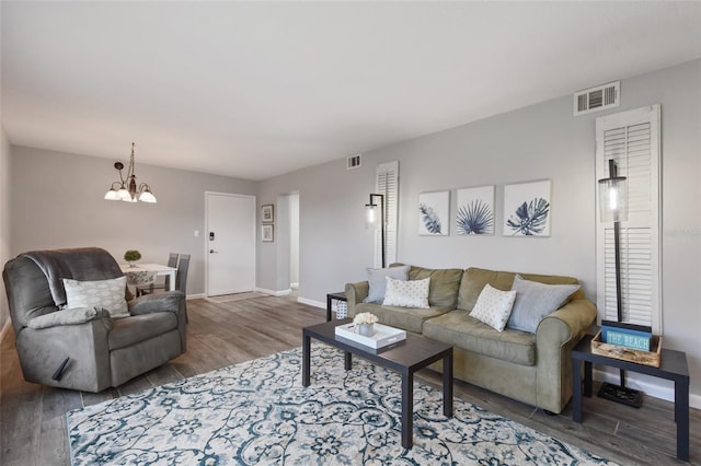 living room featuring a notable chandelier and dark hardwood / wood-style flooring