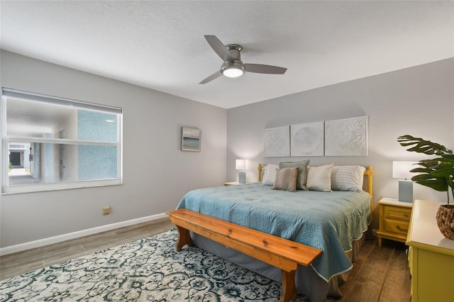 bedroom with wood-type flooring, ceiling fan, and a textured ceiling