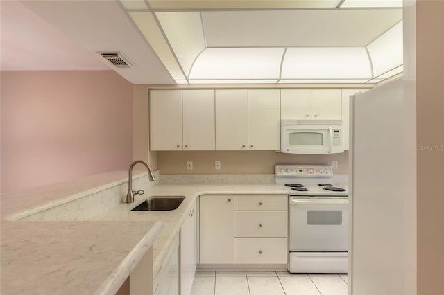 kitchen featuring sink, light tile patterned floors, and white appliances