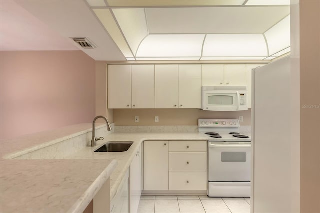 kitchen featuring light tile patterned floors, light countertops, visible vents, a sink, and white appliances