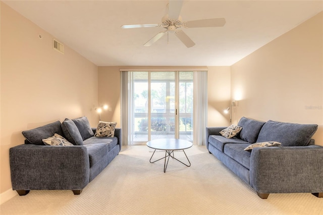 living area featuring light carpet, ceiling fan, and visible vents