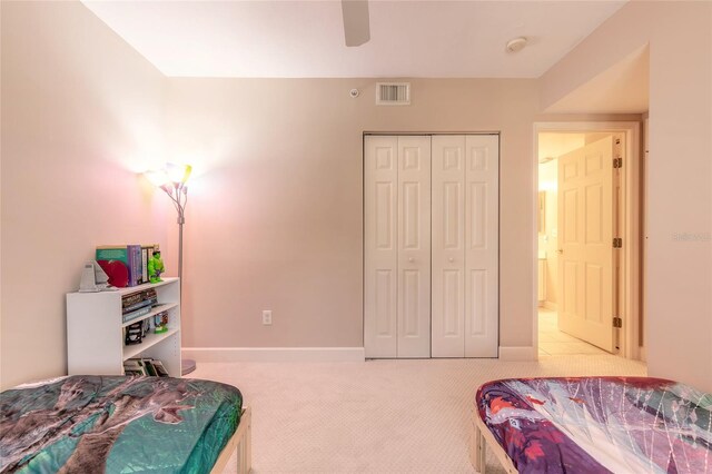 bedroom featuring a closet, ceiling fan, and light colored carpet