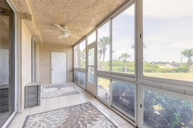 unfurnished sunroom featuring ceiling fan