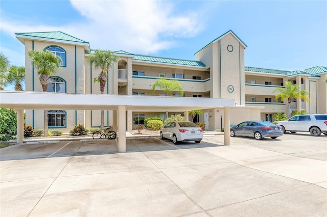 view of property with covered and uncovered parking