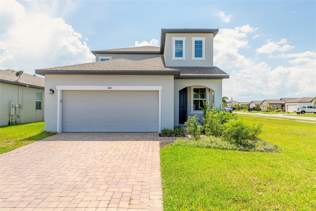 view of front of home with a garage and a front lawn