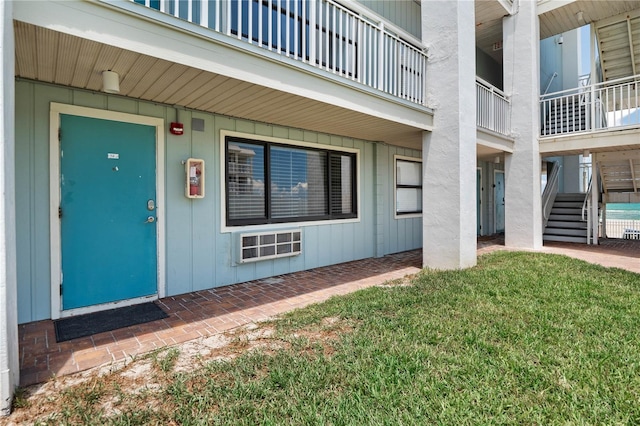 property entrance with a balcony and a lawn