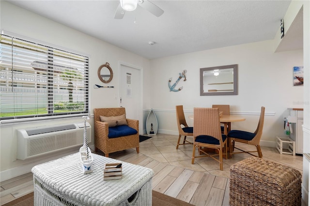 interior space featuring a ceiling fan, a textured ceiling, and baseboards