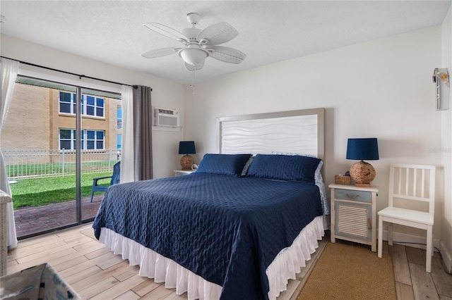 bedroom with light wood-style floors, access to outside, a wall unit AC, and ceiling fan