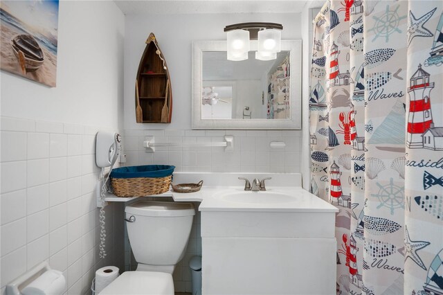 bathroom featuring vanity, toilet, decorative backsplash, and tile walls