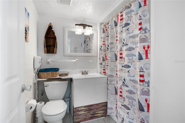 bathroom featuring tile walls, tile patterned flooring, a textured ceiling, toilet, and vanity