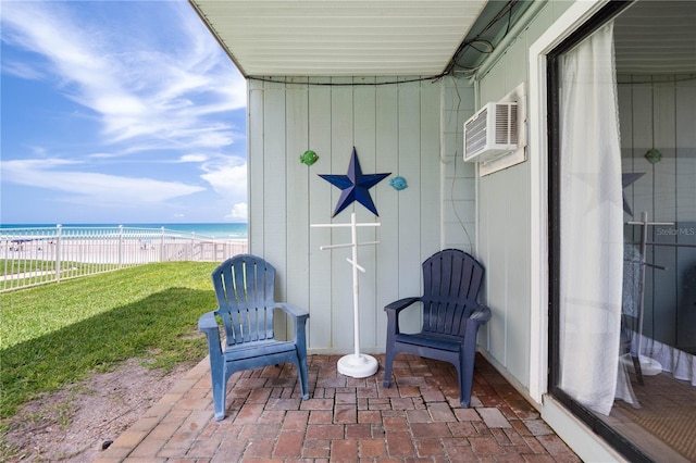 view of patio / terrace with a water view and a wall mounted air conditioner