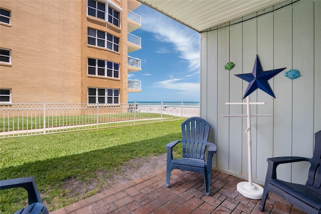 view of patio / terrace with a water view and fence