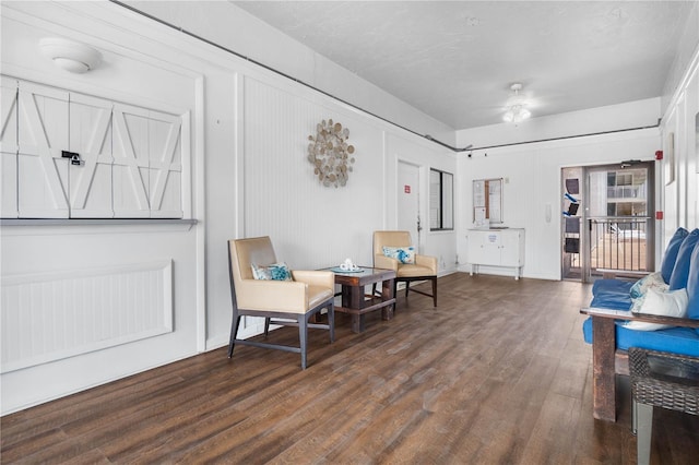 sitting room featuring wood-type flooring and ceiling fan