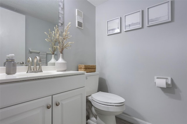 bathroom with toilet, a textured ceiling, and vanity