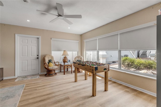 rec room featuring light wood-type flooring and ceiling fan