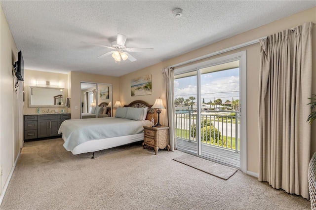 bedroom with light carpet, access to outside, ensuite bath, ceiling fan, and a textured ceiling