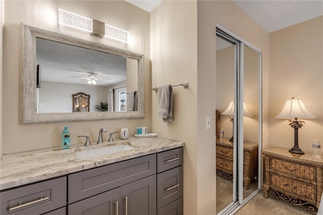 bathroom with vanity, a textured ceiling, and ceiling fan