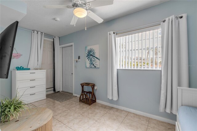 interior space with a textured ceiling and ceiling fan