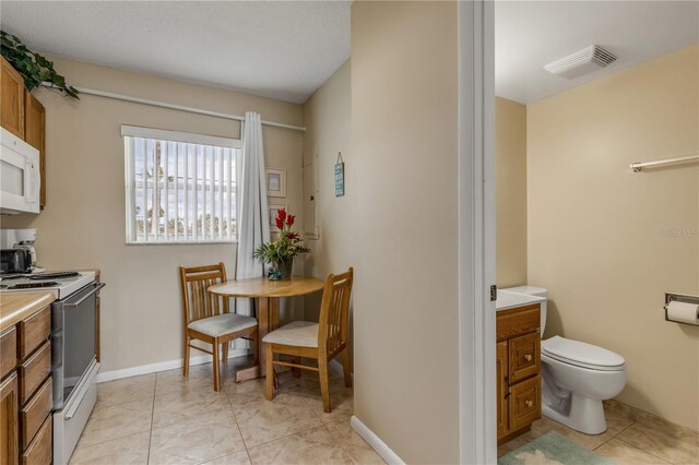 kitchen with light tile patterned floors and stainless steel electric range oven