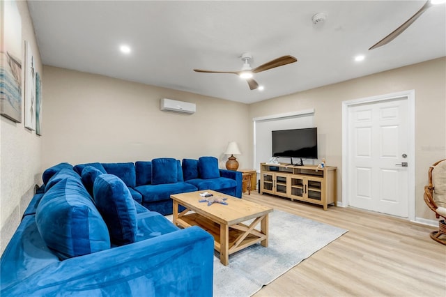 living room featuring hardwood / wood-style flooring, a wall unit AC, and ceiling fan