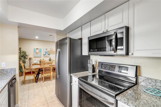 kitchen with light stone counters, white cabinetry, and appliances with stainless steel finishes