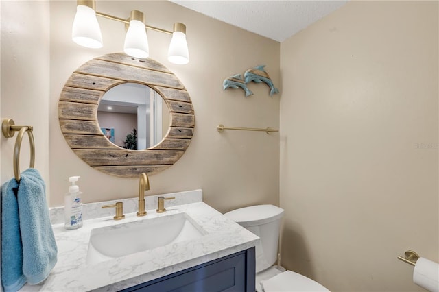 bathroom featuring vanity, toilet, and a textured ceiling