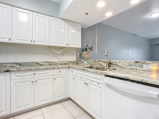 kitchen featuring sink, light tile patterned floors, white cabinetry, white dishwasher, and dark stone counters