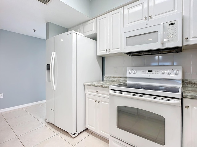 kitchen with tasteful backsplash, white appliances, light tile patterned floors, and white cabinets