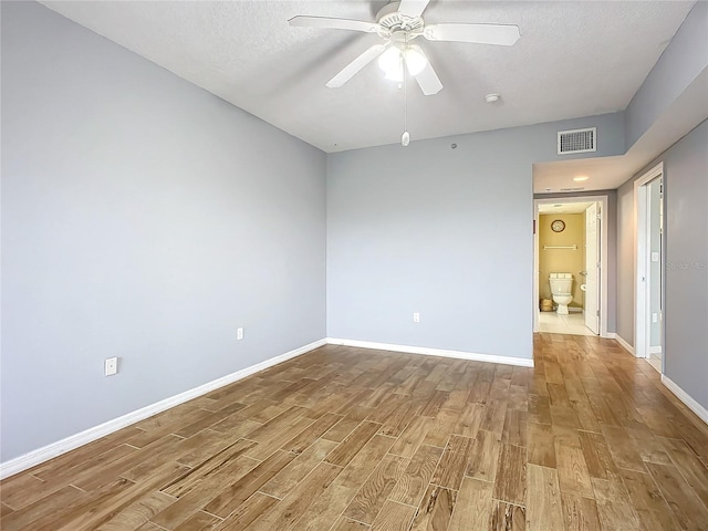 unfurnished room with ceiling fan, light hardwood / wood-style floors, and a textured ceiling