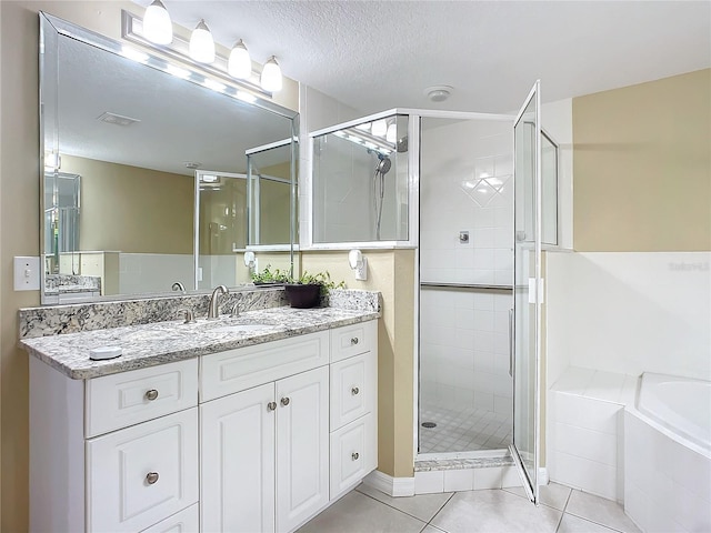 bathroom with independent shower and bath, vanity, tile patterned floors, and a textured ceiling