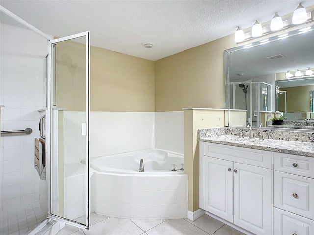 bathroom with vanity, tile patterned flooring, plus walk in shower, and a textured ceiling