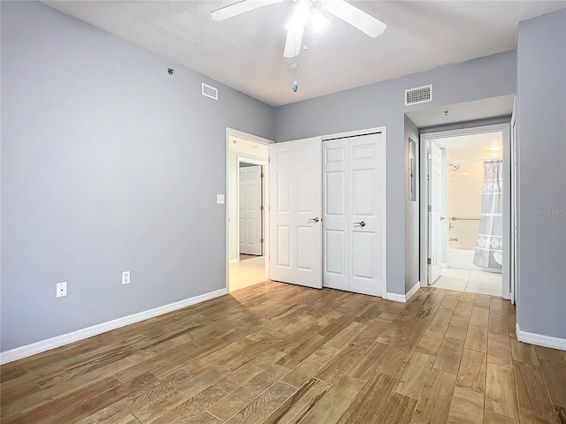 unfurnished bedroom with ceiling fan, light wood-type flooring, and a closet