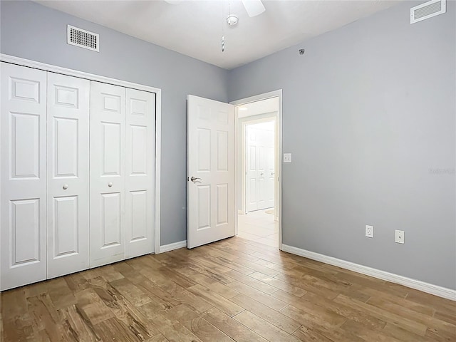 unfurnished bedroom featuring light hardwood / wood-style flooring, a closet, and ceiling fan