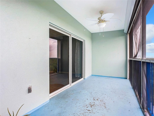 unfurnished sunroom with ceiling fan