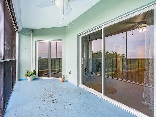 unfurnished sunroom with a wealth of natural light and ceiling fan