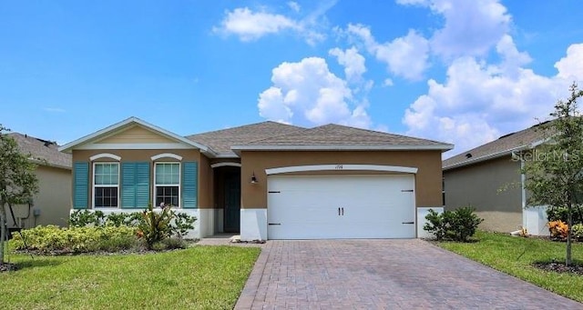 ranch-style house with a front lawn, decorative driveway, an attached garage, and stucco siding