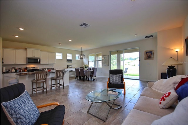 living area with recessed lighting, visible vents, baseboards, and light tile patterned floors