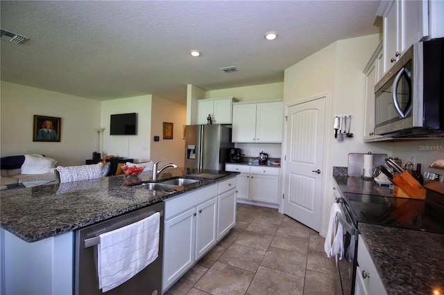 kitchen featuring appliances with stainless steel finishes, sink, light tile patterned flooring, and white cabinetry