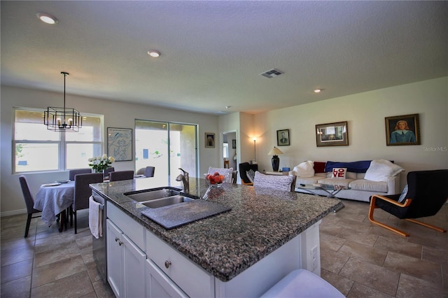 kitchen featuring tile patterned floors, a center island with sink, sink, and white cabinetry