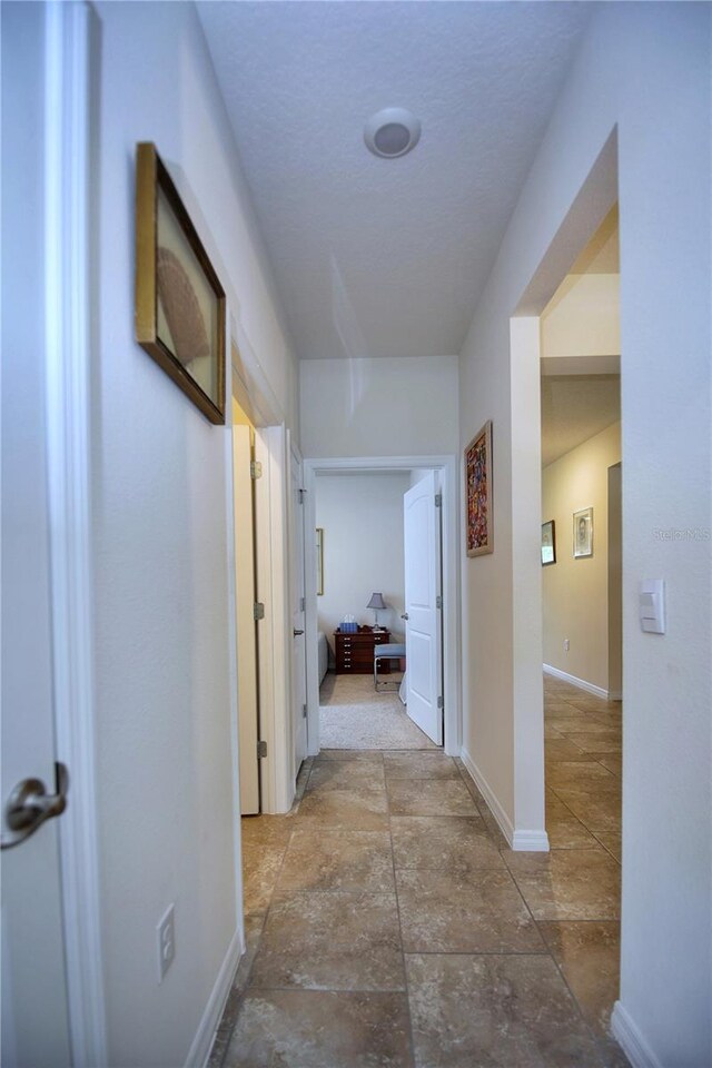 hall with tile patterned floors