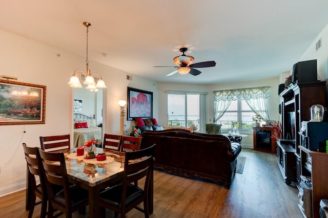 dining area featuring ceiling fan with notable chandelier and hardwood / wood-style flooring