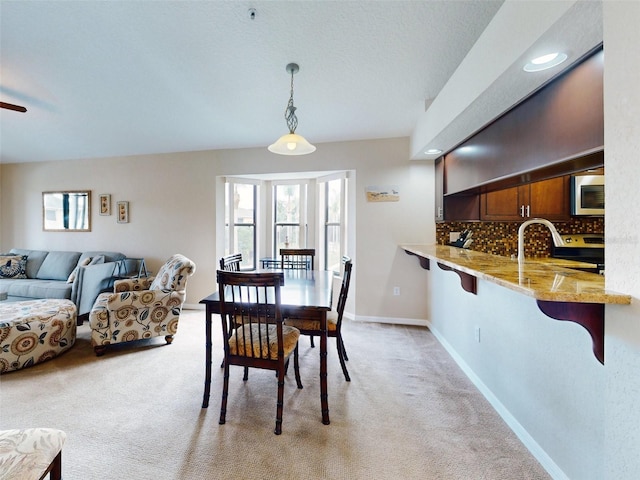 carpeted dining area with sink