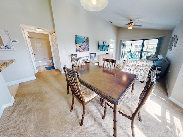 carpeted dining room with ceiling fan and high vaulted ceiling