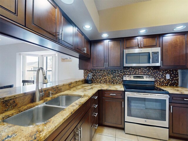 kitchen with tasteful backsplash, stainless steel appliances, sink, and light tile patterned floors